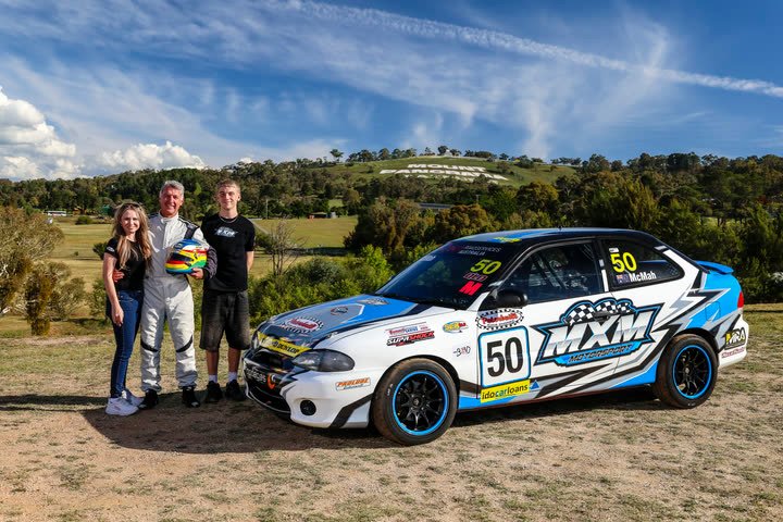 Katy, Ian and John Jr with car 50 below Mount Panorama
